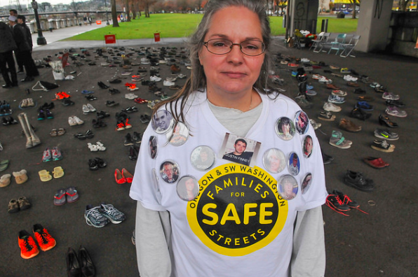 Kristi Finney, who lost her son Dustin when  a truck driver hit him from behind while biking, stands before 421 pairs of shoes symbolizing each person killed in traffic in Oregon so far this year. "The average person is indifferent to this until it happens to them," she told Bike Portland.