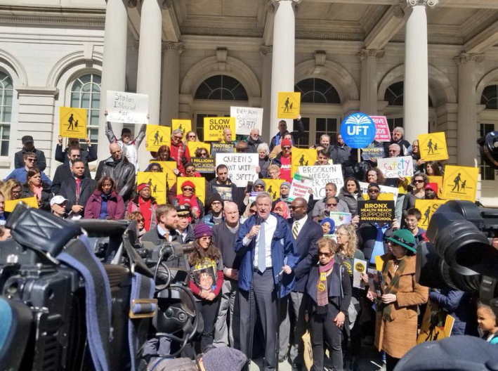 Amy Cohen, holding a photo of her son Sammy Cohen Eckstein, stands next to New York City Mayor Bill de Blasio at a Families for Safe Streets rally. Photo: Families for Safe Streets