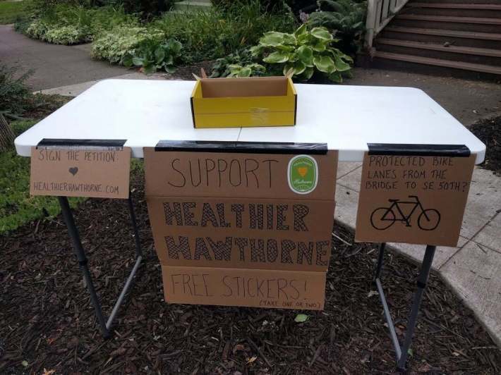 A family on SE Lincoln St offers passersby free stickers to advertise the plan.