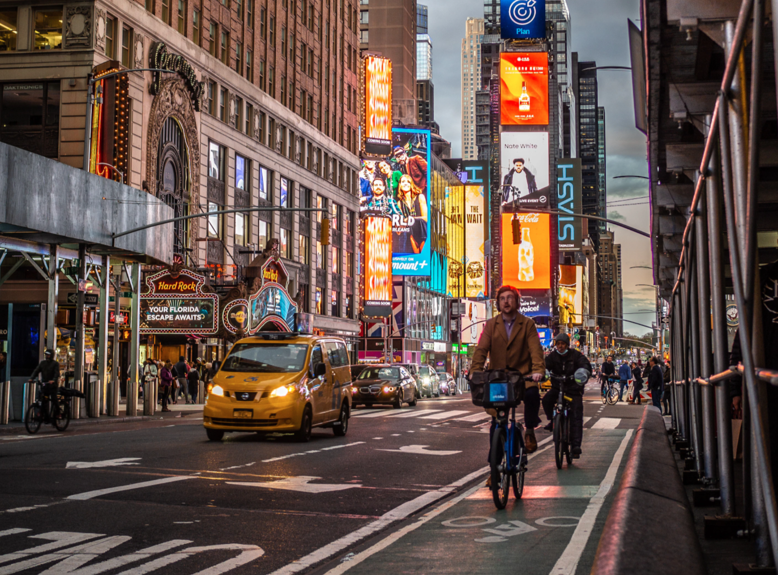 A group of cyclists bike in a bike lane near Times Square.