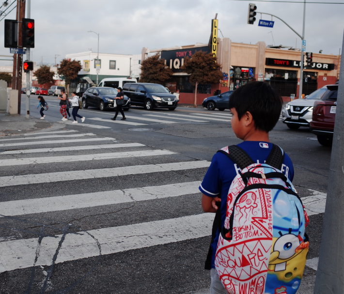 A student walking to school waiting to cross the street in East Hollywood. Photo by Gabriel Gaurano