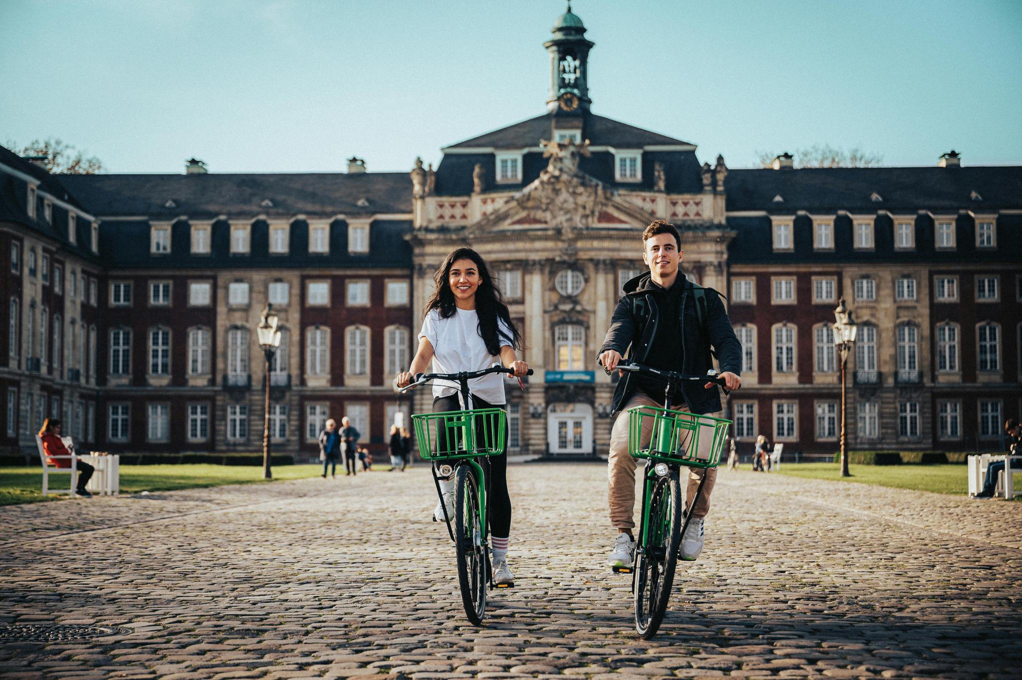 stock image of people riding bikes on a college campus